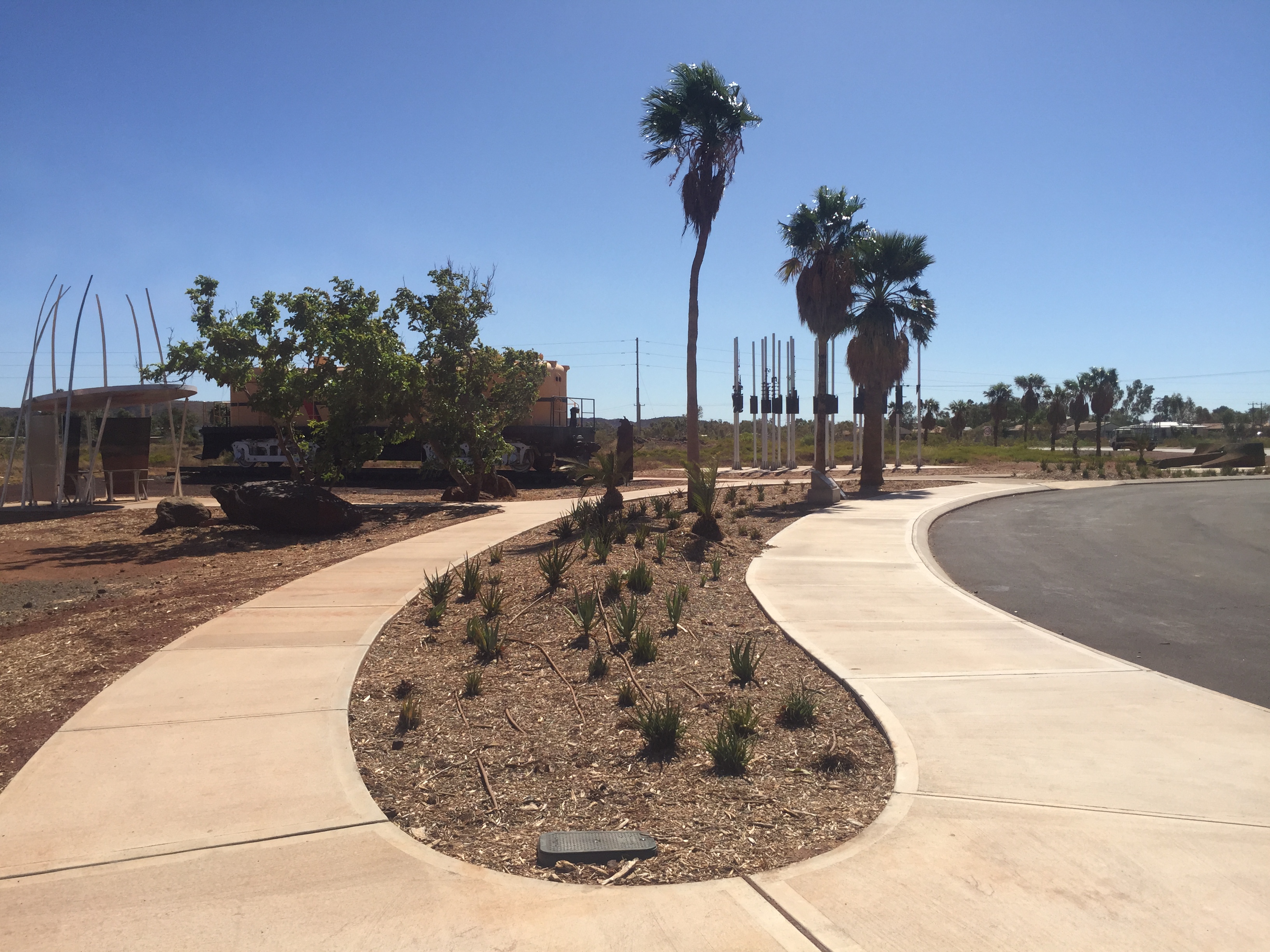 Completed broom-finished concrete pathways curving through landscaped medians in a regional Western Australian town