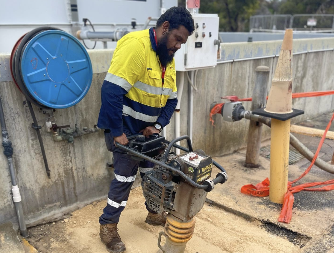YongaCivil worker operating a jumping jack compactor at a concrete works site