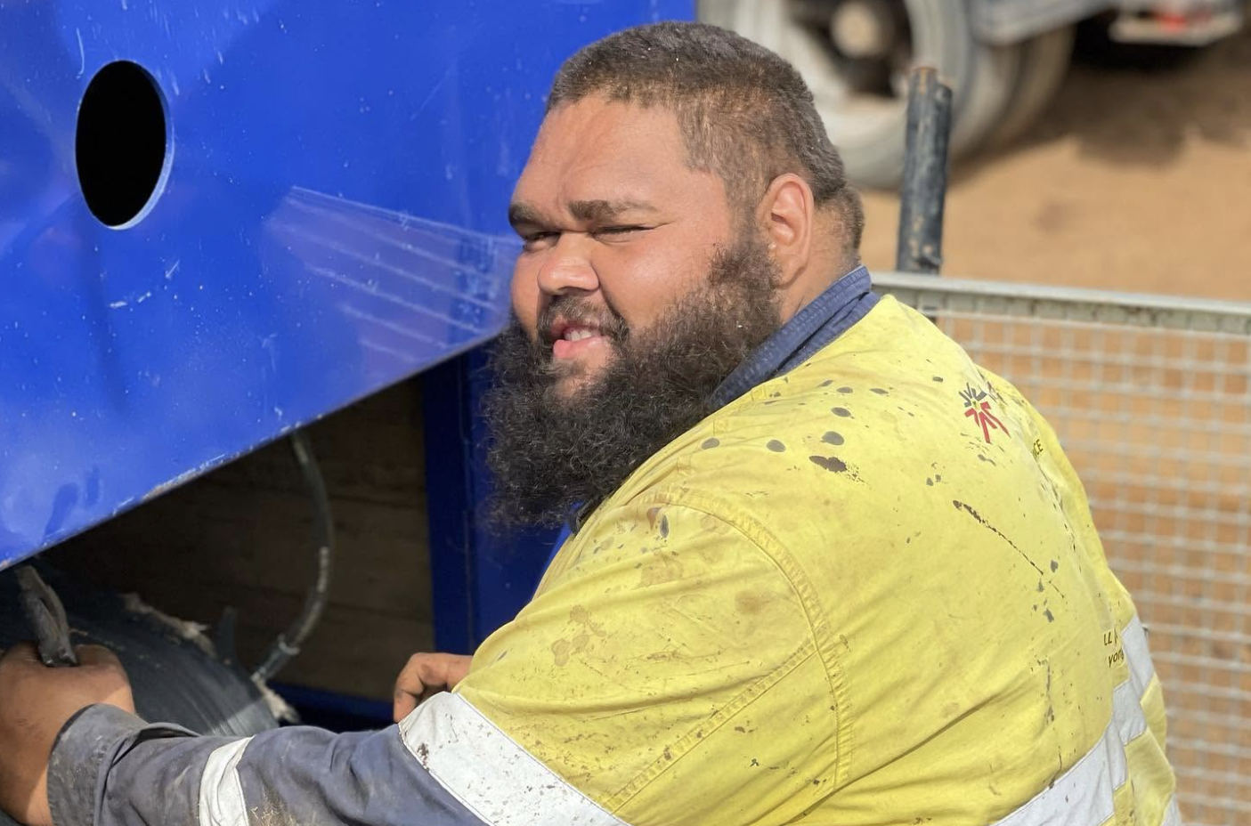 YongaCivil worker in hi-vis carrying out maintenance on blue plant equipment