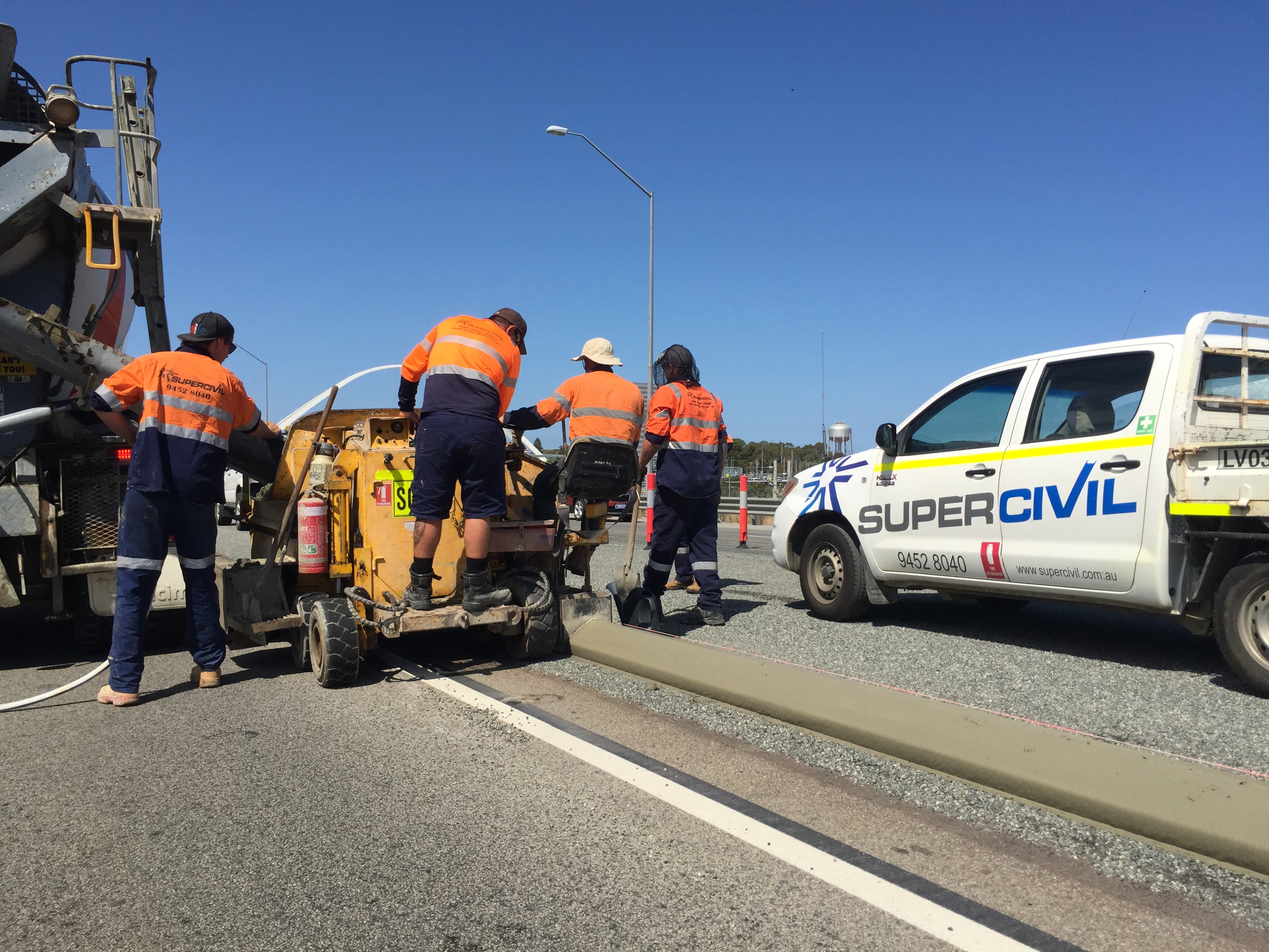 YongaCivil crew operating an extruded kerbing machine and laying continuous concrete kerb along a highway edge on a local government road project in Western Australia